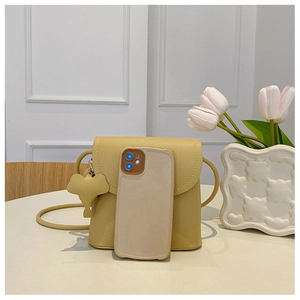 Close-up of litchi grain leather mini bag with elephant charm and phone for size reference