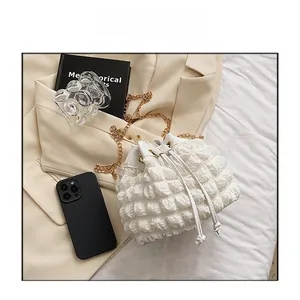 Gros plan du sac seau blanc à texture bulles avec cordon et chaîne dorée