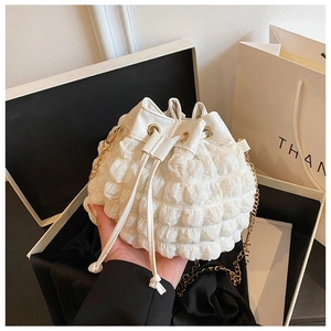 Détail du sac seau blanc à bulles avec chaîne dorée et fermeture à cordon