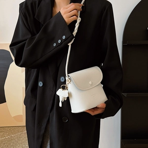 Elegant white lychee pattern bucket bag with elephant charm and woven strap detail