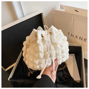 Détail de la texture bulle blanche et de la chaîne dorée sur le sac seau nuage