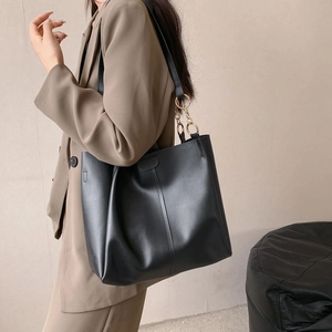 Large black matte leather tote bag with gold chain straps and vertical stitching detail
