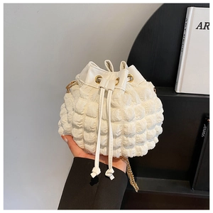 Gros plan sur le sac seau blanc à texture bulles avec détails de bandoulière dorée