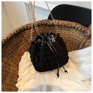 Détail du sac seau à texture bulles avec chaîne dorée et fermeture à cordon