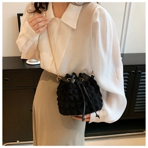 Détail du sac seau noir nuage à texture bulle avec une élégante bandoulière dorée
