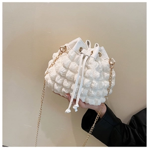 Détail du sac seau blanc à texture bulles avec cordon de serrage et chaîne dorée