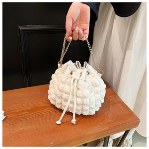 Gros plan d'un sac seau blanc à texture plissée bulle et chaîne dorée