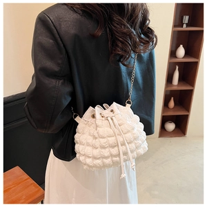 Détail de la texture bulle blanche sur le sac seau avec cordon et bandoulière en chaîne dorée