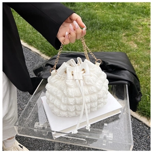 Détail du tissu à bulles blanc et de la chaîne dorée sur le sac seau