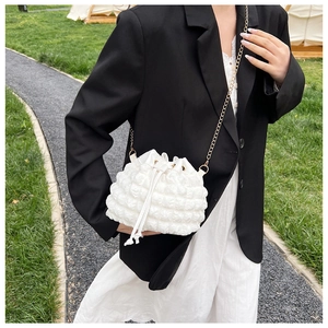 Détail du sac seau blanc à texture bulles avec chaîne dorée et fermeture à cordon