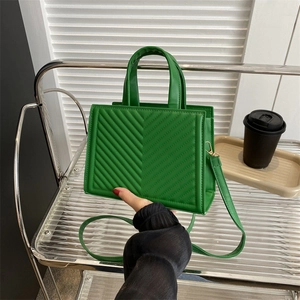 Green quilted small crossbody bag with circular handle and V-pattern stitching