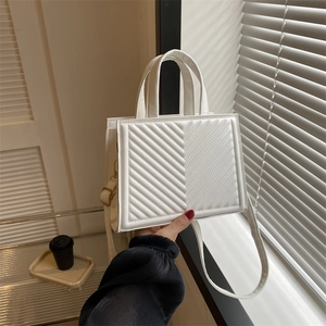 White quilted square handbag with chic V-pattern stitching and adjustable gold strap