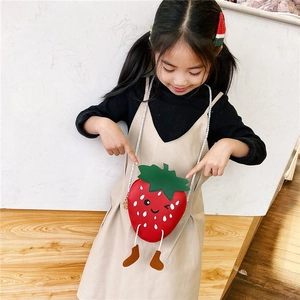 Detailed view of child wearing a cute strawberry-shaped red PU leather crossbody bag