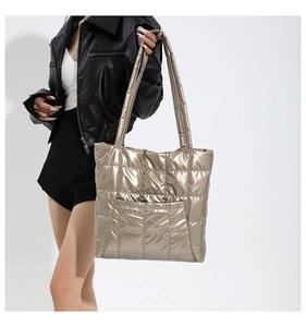 Détail du sac cabas matelassé or champagne avec larges anses et poche avant spacieuse