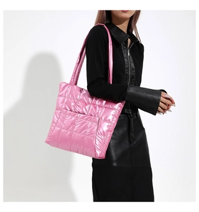 Gros plan d'un sac cabas matelassé rose brillant avec coutures carrées et longues anses