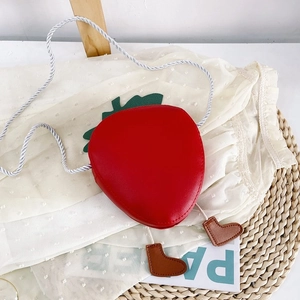 Detail of red strawberry shaped kids crossbody bag with cute feet and white rope strap