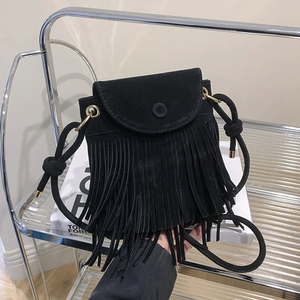 Dettaglio di una borsa a tracolla nera con frange, texture scamosciata e nappe decorative