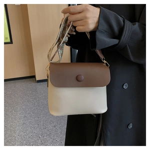 Detail of cream and brown crossbody bag with bohemian patterned wide fabric strap