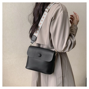 Detail of black matte crossbody bag with vintage geometric jacquard wide strap