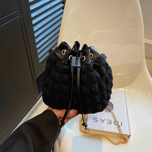 Sac seau noir à bulles avec cordon de serrage et bandoulière chaîne dorée en main