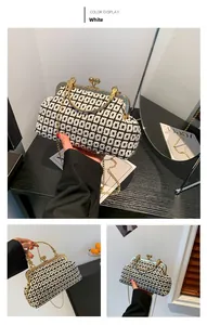 Detail of white knit handbag with geometric patterns, gold lock and metal chain strap