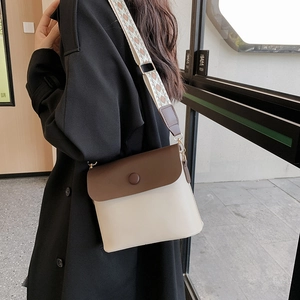 Retro shoulder bag with brown patchwork cover and woven strap in a modern setting