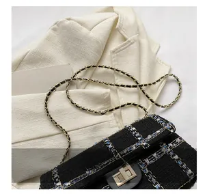 Gros plan d'un sac en tweed noir avec fermoir doré et détails de bandoulière chaîne