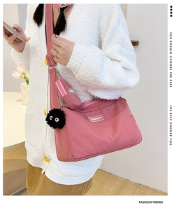 Detail of pink nylon crossbody bag set with small round pouch and soot sprite charm