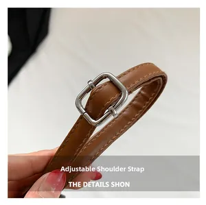Close-up of adjustable brown leather shoulder strap with silver buckle and fine stitching