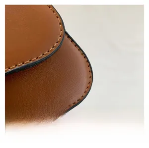 Macro detail of brown leather bag showing premium lychee texture and fine stitching