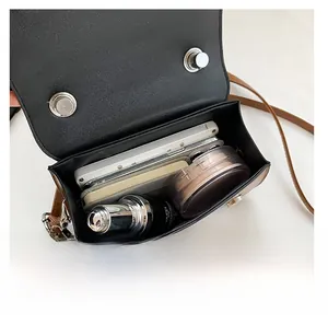 Detail view of the spacious inner compartment of the brown contrast flap crossbody bag