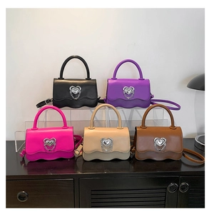 Detail of colorful small square handbags with wave-shaped bottom and silver heart buckle