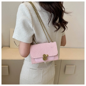 Détail du sac rose clair avec texture ondulée et boucle dorée en forme de gourde