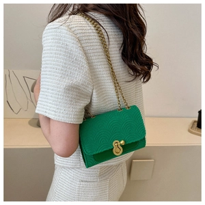 Détail du sac à bandoulière vert vif à texture ondulée avec chaîne dorée et fermoir