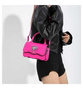 Fashionable rose pink crossbody bag with a wave edge and silver heart buckle detail