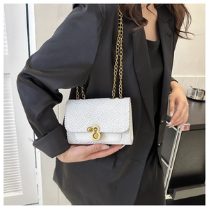 Gros plan détaillé d'un sac blanc à chaîne avec fermoir doré porté par un mannequin