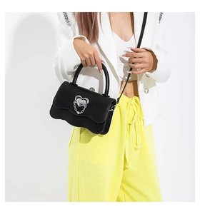Fashionable black leather handbag featuring wave edges and silver heart buckle detail