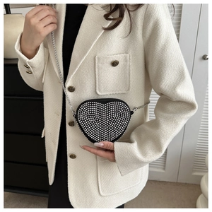 Detailed close-up of heart-shaped handbag featuring silver studded beads and chain strap