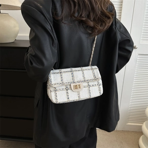 Sac à rabat chic en tweed bouclé avec bandoulière dorée porté par un mannequin