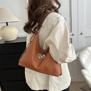 Sac hobo marron caramel avec chaîne argentée et logo métallique en scène lifestyle