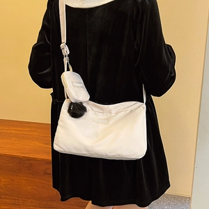 White large capacity crossbody pillow bag with small coin purse and pompom charm on model
