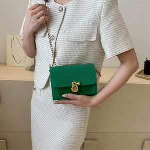 Sac bandoulière matelassé vert chic avec chaîne dorée et boucle sur le mannequin