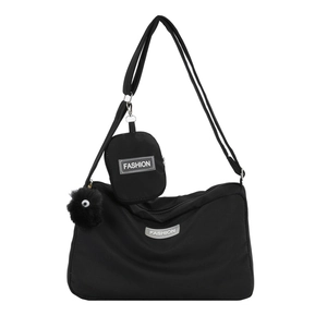 Black nylon crossbody pillow bag with small detachable pouch and plush keychain charm
