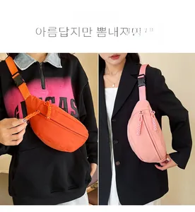 Close-up of durable nylon waist bag in orange and pink with woven zipper pulls