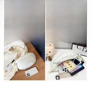 Detail view of white minimalist crossbody bag showing its large internal storage capacity