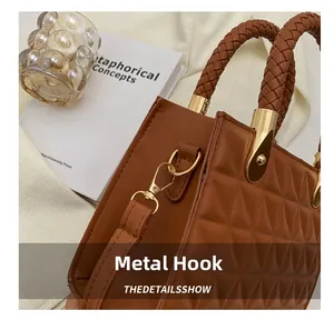 Detail of the golden metal hook and brown quilted texture on the fashion shoulder bag