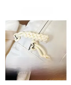 Close-up of the ivory white chest bag showing durable zipper with textured woven puller