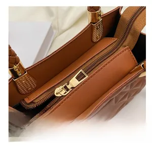 Detailed shot of smooth golden zipper and brown quilted leather texture on handbags