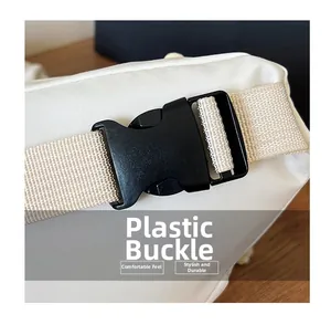 Detail of the high-quality black plastic buckle and durable woven strap on the white bag