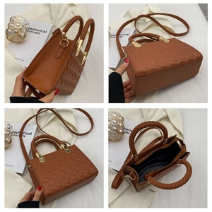 Detail view of brown quilted handbag with braided handle and gold metal hardware links